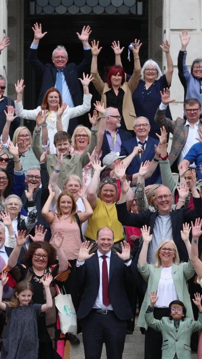 Communities minister Gordon Lyons (centre front) with campaigners from the deaf community at a rally outside the Parliament Buildings at Stormont