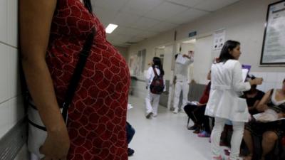 A pregnant woman waits for a routine general check-up, which includes Zika screening.