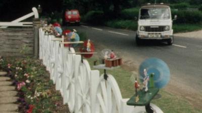 Jack Wild's windmills lined up on his white fence.