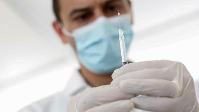 A man holds a coronavirus vaccine