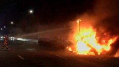 Firefighter hosing burning truck