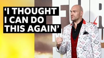 Tyson Fury at a press conference ahead of his fight on Saturday. He is wearing a white suit jacket.