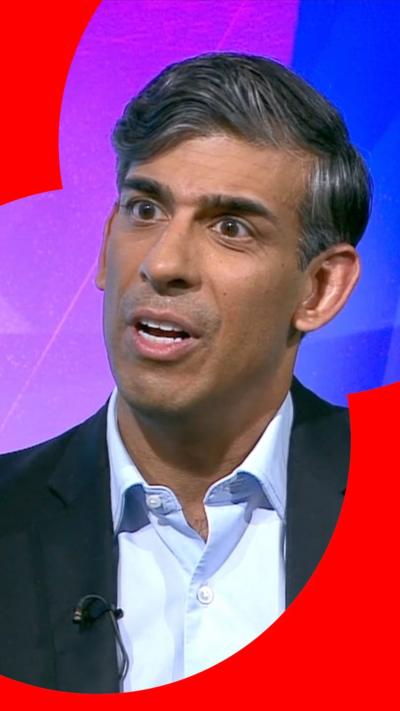 Rishi Sunak has dark hair and is wearing a black suit with a light blue shirt