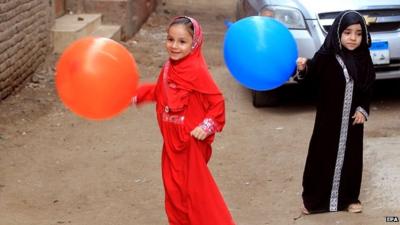 Girls carry colourful balloons