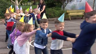 Children doing the conga line at a school birthday party