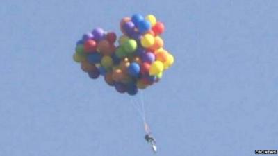 An image of the man flying over Calgary in a chair carried by balloons taken from footage of the incident - 6 July 2015