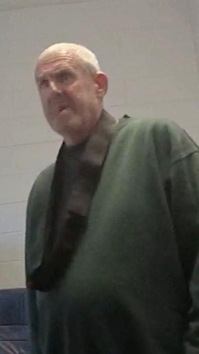 Old man with short white hair in a green jumper