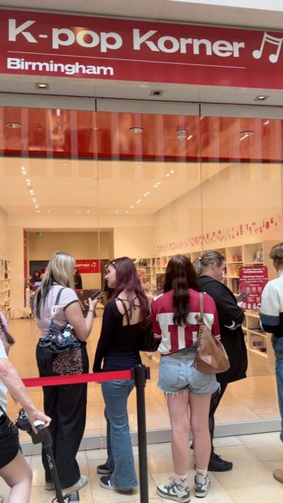 Young women queue up outside K-pop Korner in Birmingham ahead of its opening