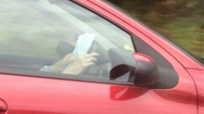 A submitted picture of a driver reading at the wheel