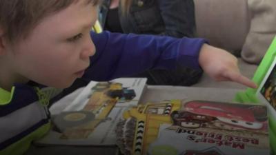 A boy points to his toy