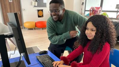 Newsround's De-Graft Mensah with a young girl, Rama, playing Minecraft
