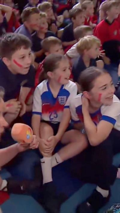 Children in England kits with their faces painted 