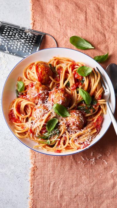 Top-down view of a white bowl containing meatballs and spaghetti