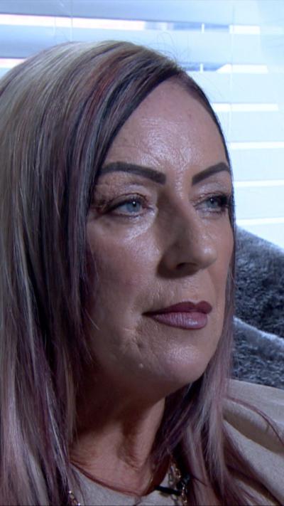 close-up of a woman's face. She has long straight hair and is wearing make up