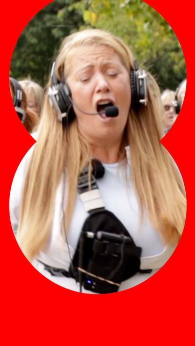 Woman in white tshirt sings into headset