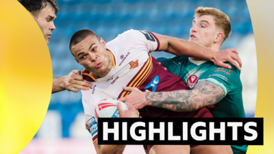 Tui Lolohea of Huddersfield is tackled by Alex Walmsley and George Delaney of St Helens