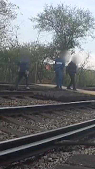 People standing on a railway track.