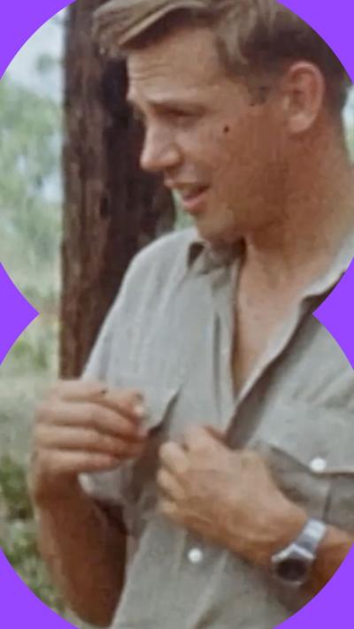 A man with short, blonde hair looks at something off-camera