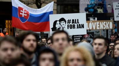 Placards are raised by the crowd