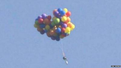 An image of the man flying over Calgary in a chair carried by balloons taken from footage of the incident - 6 July 2015