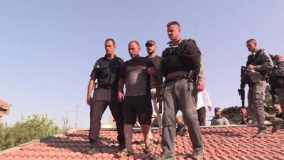 Police escort Palestinian man off roof