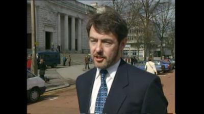 A man outside of a courthouse.