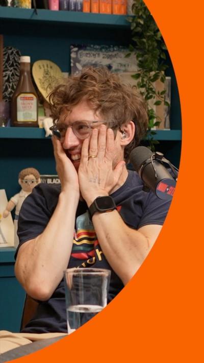 A man with short hair holds his hands to his face in anguish.