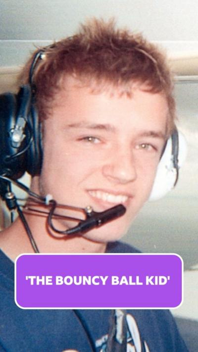 a young man with short brown spiky hair wears a set of headphones while sitting in a plane