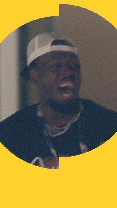 Usain Bolt wearing a white cap backwards. He has his mouth open as he celebrates.