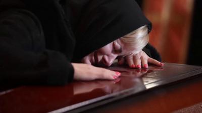 A woman cries over the coffin of a dead soldier