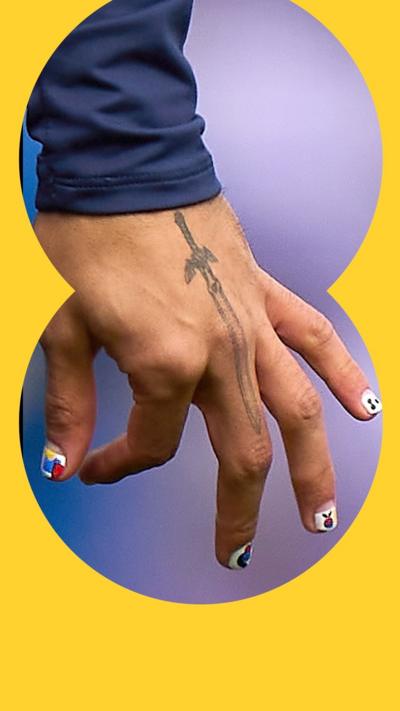 A hand with a tattoo and nail varnish