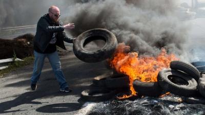 Employees of the MyFerrylink company stage a protest by blocking the A16 highway with a tyre fire in Calais