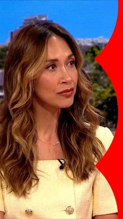 Myleene Klass sits on the BBC Breakfast sofa. She has long wavy brown hair and wears a yellow top.