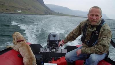 A man on his boat off the coast of the Isle of Mull