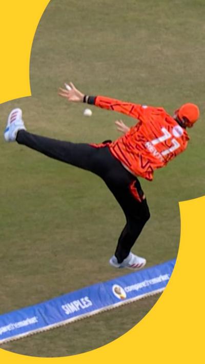 Matthew Revis jumping over the boundary to stop a six