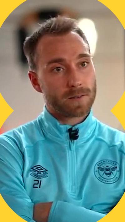Christian Eriksen has short blonde hair and is wearing a zipped up blight blue jacket