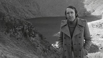 A reporter in front of the ghostly lake in Wales.