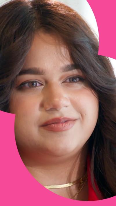A woman with long brown hair wearing a gold necklace.