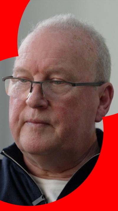 Shark attack victim Peter Smith seen in an up close shot - he has a neutral expression with his mouth closed, is wearing glasses, a quarter length zip top,  and has whispy white hair