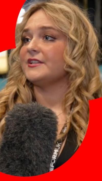 Women with long wavy hair speaking into a microphone