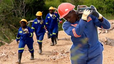 A female miner carrying equipment