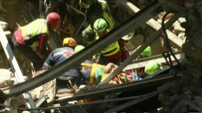 Man on stretcher being removed from destroyed building in Accumoli