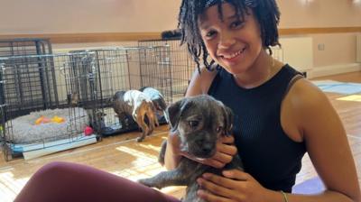 A women cuddling a puppy