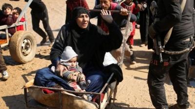 Woman and child being pushed on cart