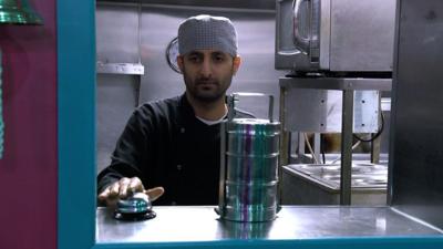 A steel tiffin on a takeaway counter