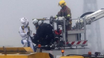 Activist dressed as polar bear speaking to staff on hydraulic lift