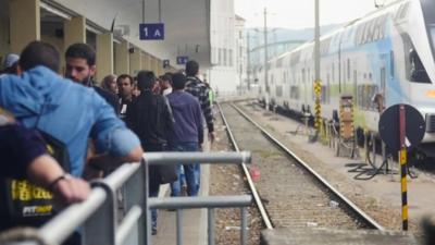 Migrants on platform at Vienna's Westbahnhof stationas they wait to see whether trains will take them any further west towards Germany