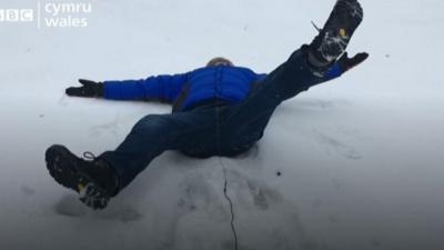 Derek Brockway attempts a snow angel