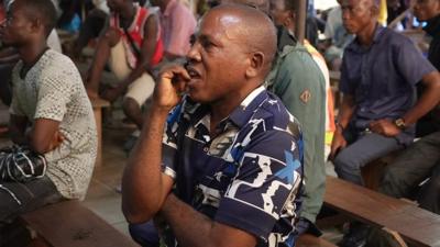 A male fan bites his lip and looks nervous watching the Super Falcons World Cup game in a viewing centre