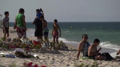 Memorial and tourists on Tunisian beach in Sousse